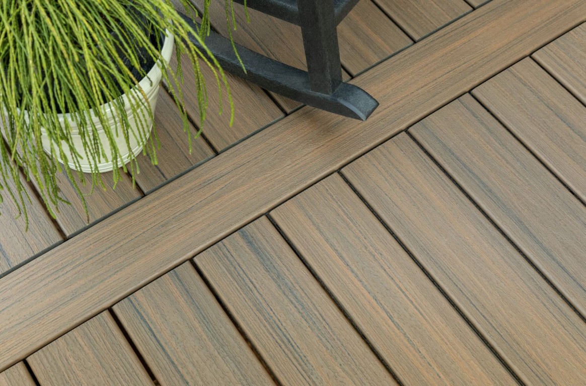 Low-maintenance composite deck material with realistic wood grain texture